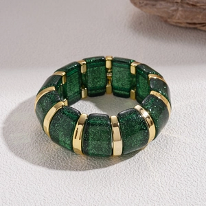 Detail of green glitter acrylic rectangular beads with gold spacers on an elastic bracelet