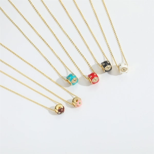 Detail of colorful enamel doughnut charms with evil eye motif on gold chains