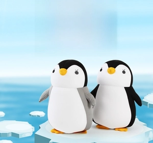 Detail of penguin-shaped plush neck pillows in gray and black with soft cartoon design