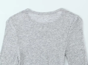 Close-up of crew neck stitching and grey knit fabric texture on a slim fit cotton T-shirt
