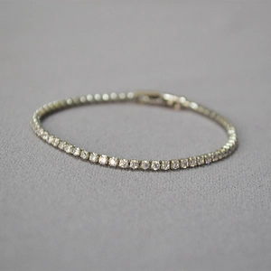 Elegant minimalist silver tennis bracelet with sparkling cubic zirconia on gray fabric
