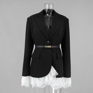 Close-up of black blazer with white lace hem and sleeves with a gold buckle belt