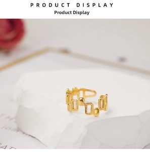 Detail of 18k gold plated irregular geometric hollow ring on white stone display