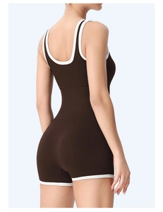Detail of ribbed dark brown bodysuit featuring white contrast piping and open back