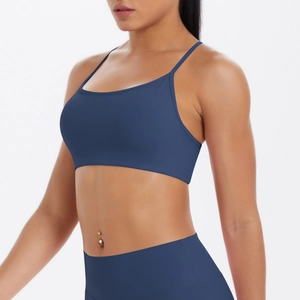 Détail des fines bretelles croisées sur le soutien-gorge de sport bleu foncé dos nu