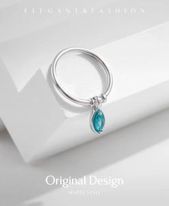 Macro detail of S925 sterling silver ring featuring a marquise cut blue gemstone charm