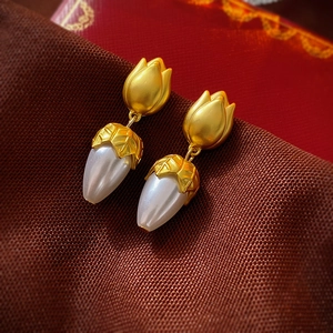 Detailed macro view of vintage gold flower stud earrings with elegant water drop pearls
