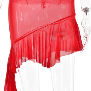 Detail of red mesh dress showing asymmetric ruffled hem and sheer fabric texture