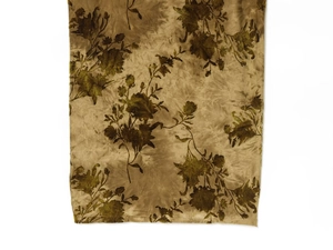 Close-up of golden brown satin fabric with floral print and pleated velvet texture