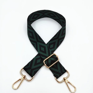 Detail of green and black geometric diamond woven strap with gold metal hooks