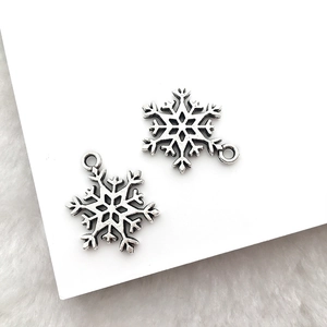 Makroaufnahme von zwei antiken Silber-Schneeflocken-Anhängern für DIY-Weihnachtsschmuck