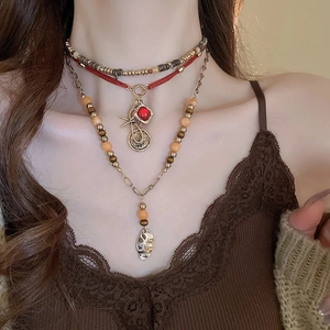 Detailed layered bohemian necklace with red woven cord, coin charms and leaf pendant