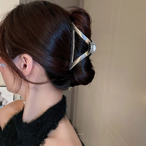 Sleek silver triangular hollow metal hair claw clip shown on a minimalist hairstyle