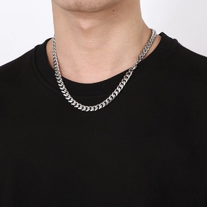 Close-up of a silver-tone beveled Cuban link necklace worn on a model neck