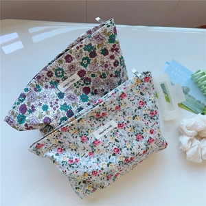 Detailed macro of floral canvas toiletry bags with simple wish labels and metal zippers