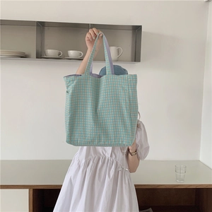 Bolso tote de lona a cuadros azules y blancos en un ambiente de estilo minimalista