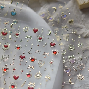 Macro shot of gold nail art stickers with moon, stars, heart, and butterfly designs