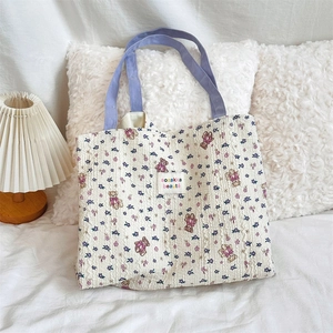 Detail of floral bear print canvas tote with purple straps and wrinkled texture fabric