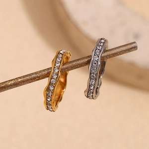 Detailed macro view of gold and silver irregular wavy rings with micro-pave crystals