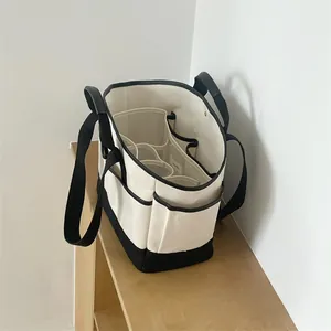 Detail of canvas diaper bag showing black and white contrast with multi-pocket interior