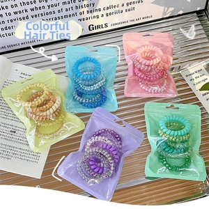 Detail of colorful gradient telephone wire hair coils in matte frosted packaging pouches