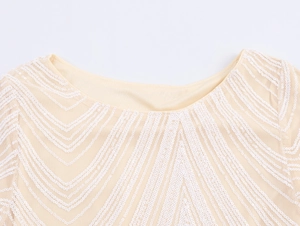 Close-up of champagne sequin dress with elegant V-shaped patterns and round neckline