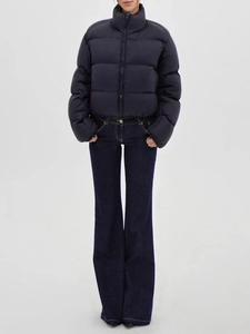 Women's navy puffer jacket and vintage flare jeans set shown on studio model