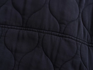Détail de la veste bomber en coton délavé bleu marine avec texture matelassée