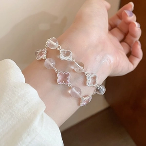 Detail of pink and clear crystal four-leaf clover beaded bracelet worn on a female wrist