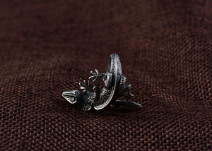 Detailed macro shot of vintage silver lizard ring with intricate scale textures on linen