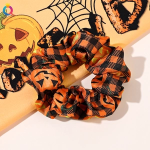 Detail of Halloween scrunchie with orange pumpkin faces and black checkered fabric pattern