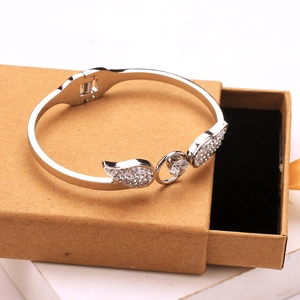 Silver stainless steel open bangle with angel wings and heart-shaped cubic zirconia