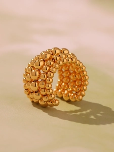 Macro shot of multi-layer golden beaded ring with high-polished metallic weave texture