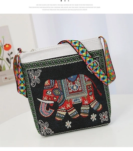 Detail of colorful elephant embroidery and geometric woven strap on black canvas bag