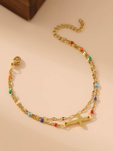 Detail of 18K gold layered bracelet featuring colorful beads and a cross pendant