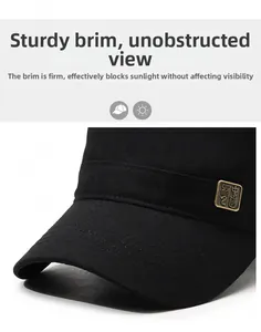 Detailed macro view of black canvas flat top hat featuring a vintage bronze metal emblem