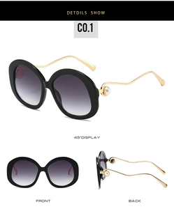 Detail view of round pearl sunglasses with gold wavy temples and black frames