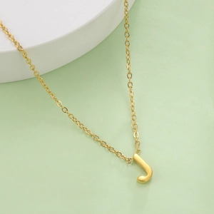 Macro shot of 18k gold plated stainless steel letter J pendant on a dainty chain