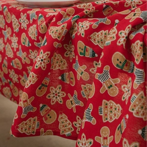 Red Christmas tablecloth with gingerbread man and pine tree patterns in cotton linen fabric