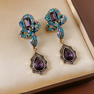 Gros plan sur les boucles d'oreilles serpent vintage avec strass multicolores