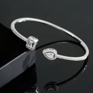 Close-up of adjustable silver cuff bracelet with pear and rectangular cut crystals