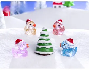 Macro detail of miniature resin Christmas ducks with glitter and snowy tree decor