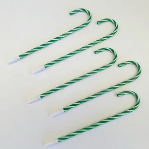 Close-up of five green and white candy cane shaped ballpoint pens for Christmas
