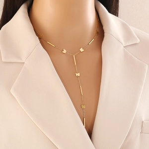 Elegant gold Y-shaped stainless steel necklace with butterfly pendant on model in beige blazer