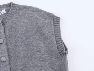 Détails de gilet en tricot gris avec bordures côtelées et boutons assortis