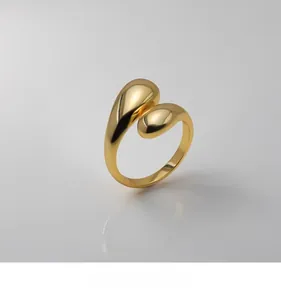 Macro shot of polished gold waterdrop ring showing high-shine metallic texture and curves