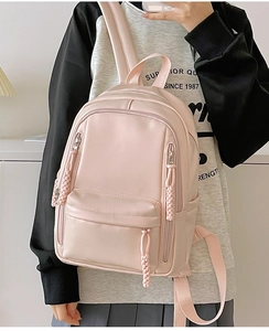 Pink minimalist backpack with braided zipper pulls shown in a mirror selfie perspective