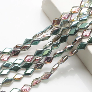 Macro view of multi-faceted emerald green crystal glass beads with iridescent coating
