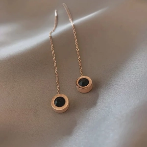 Rose gold Roman numeral ear threads with black zircon pendants on silk background