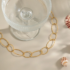 Detail of 18K gold-plated oval link necklace with summer shells and glass props
